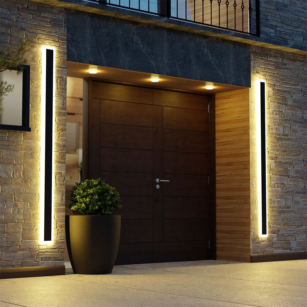 Slim black vertical outdoor wall light casting a warm glow