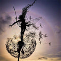 Black metal garden sculpture with fairy silhouettes and dandelion seed heads