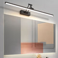 Adjustable linear wall lamp mounted above a mirror