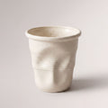 Textured ceramic mug with rounded rim and ribbed body