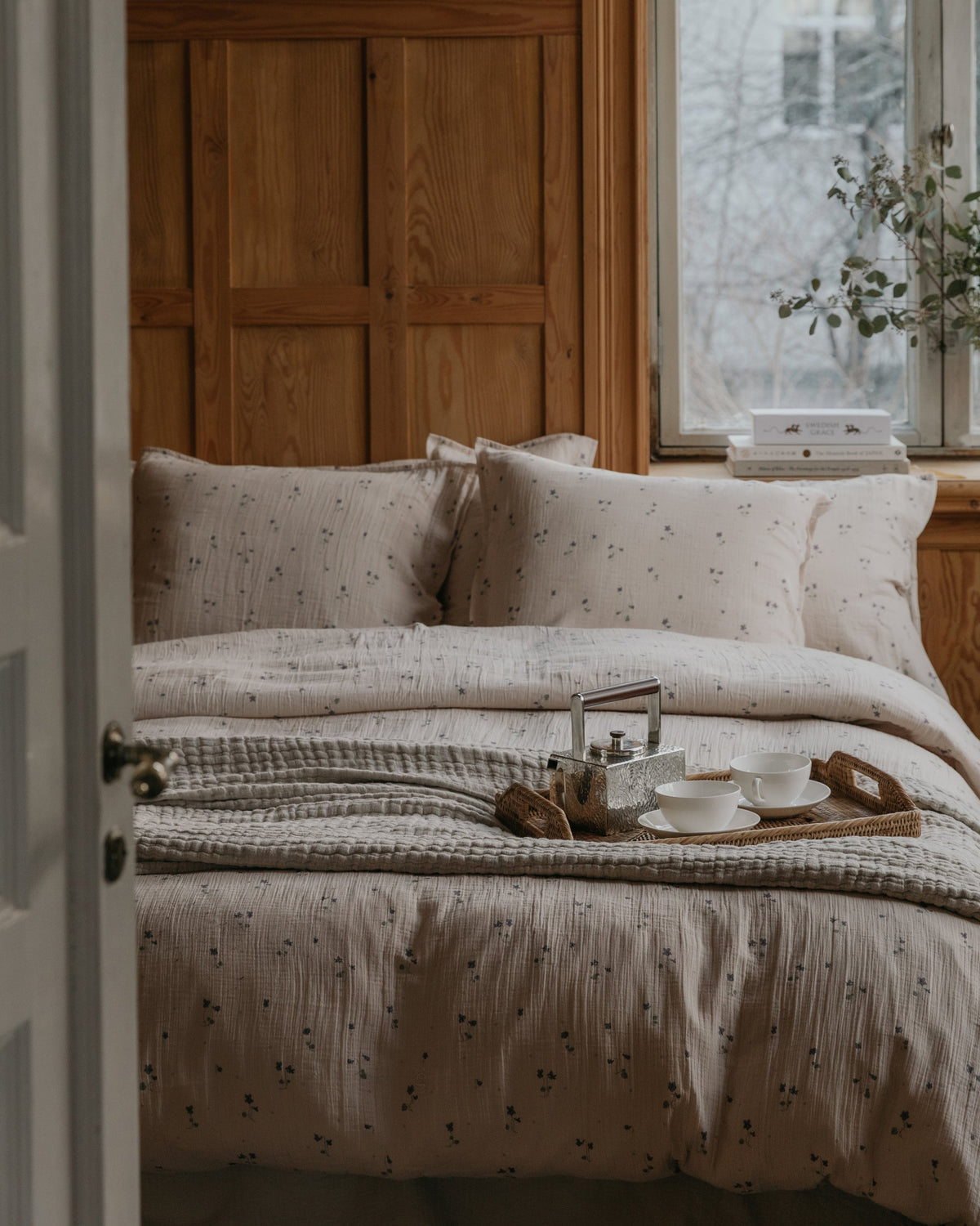 Beige muslin pillowcase with small purple floral pattern and gathered texture
