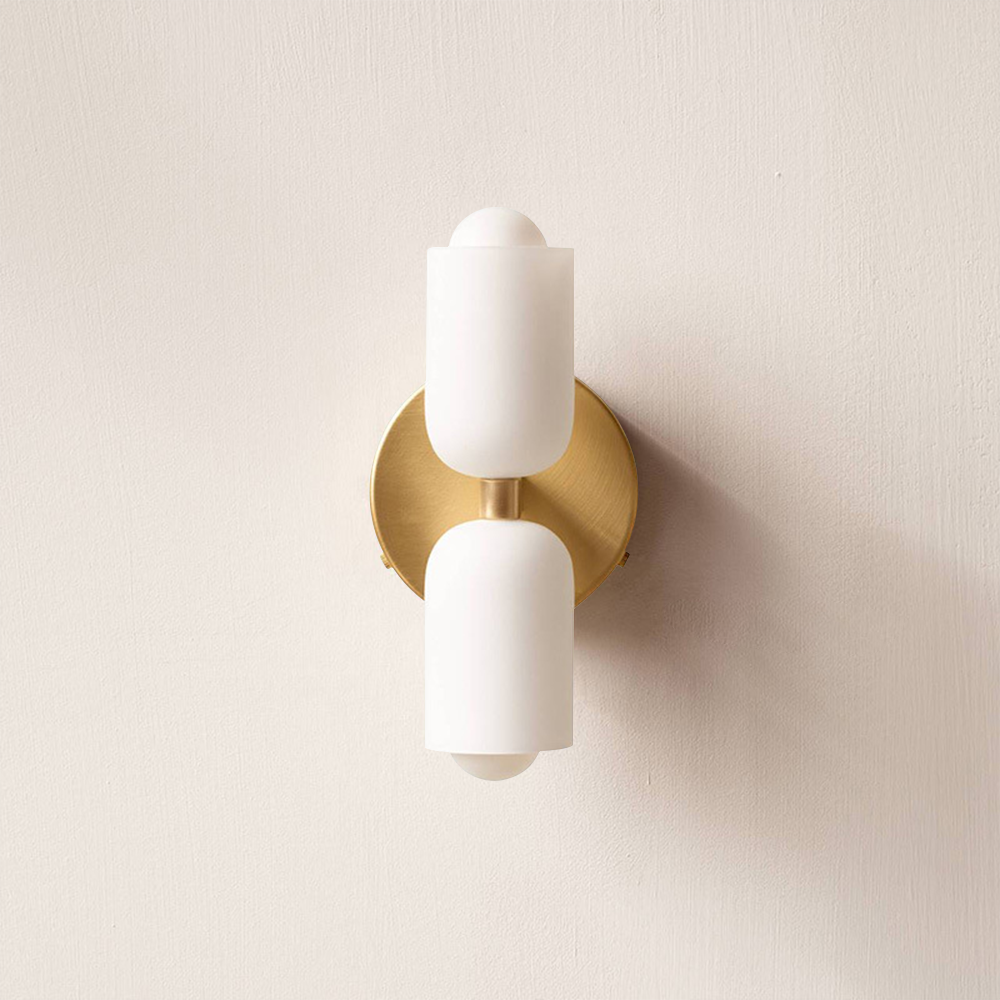 Double head wall sconce with two cylindrical shades and round wall plate