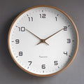 Round minimalist wall clock with large dark numerals and slim hands