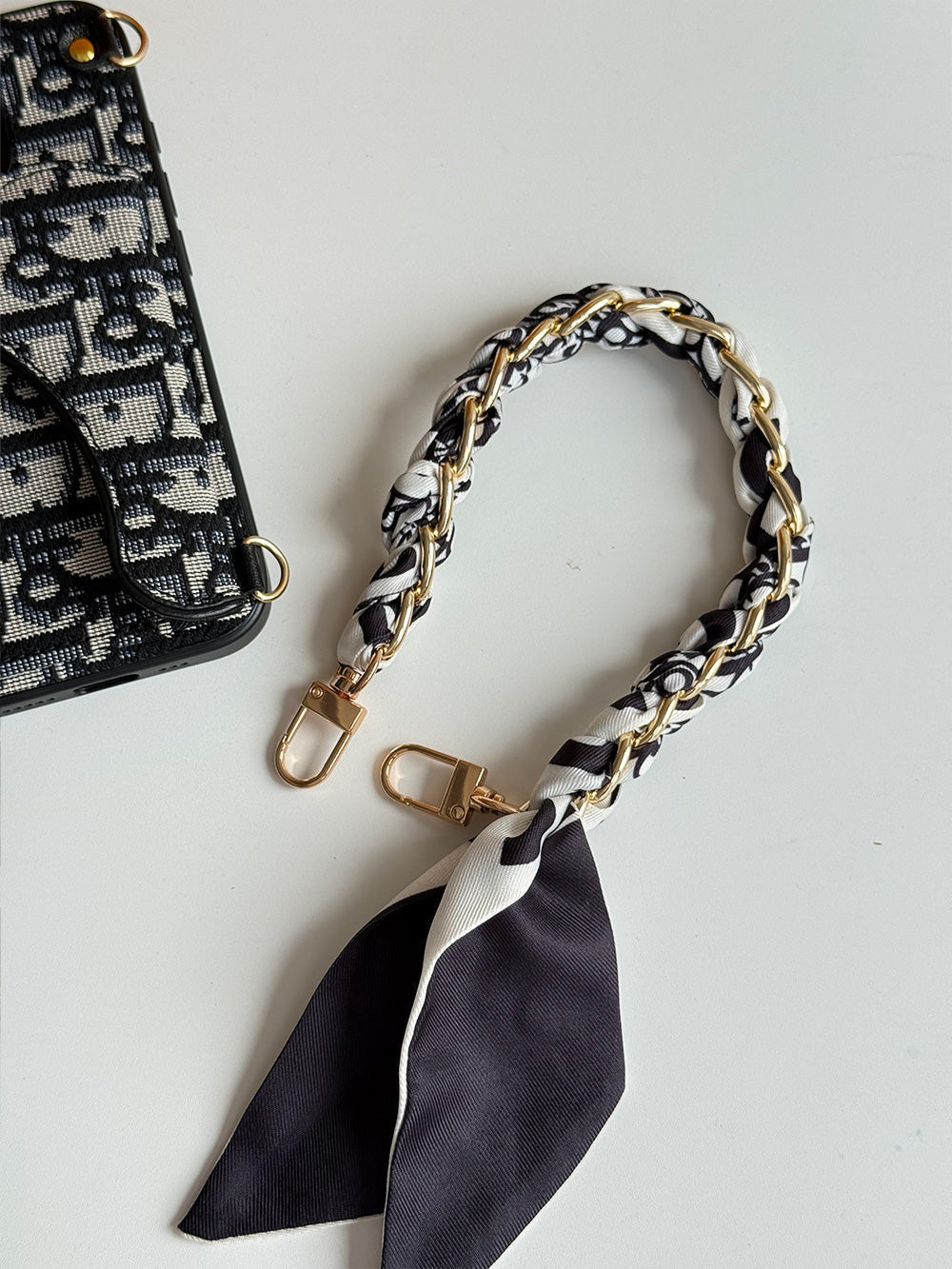 Black and cream geometric phone case with card-holder flap and gold-tone clip