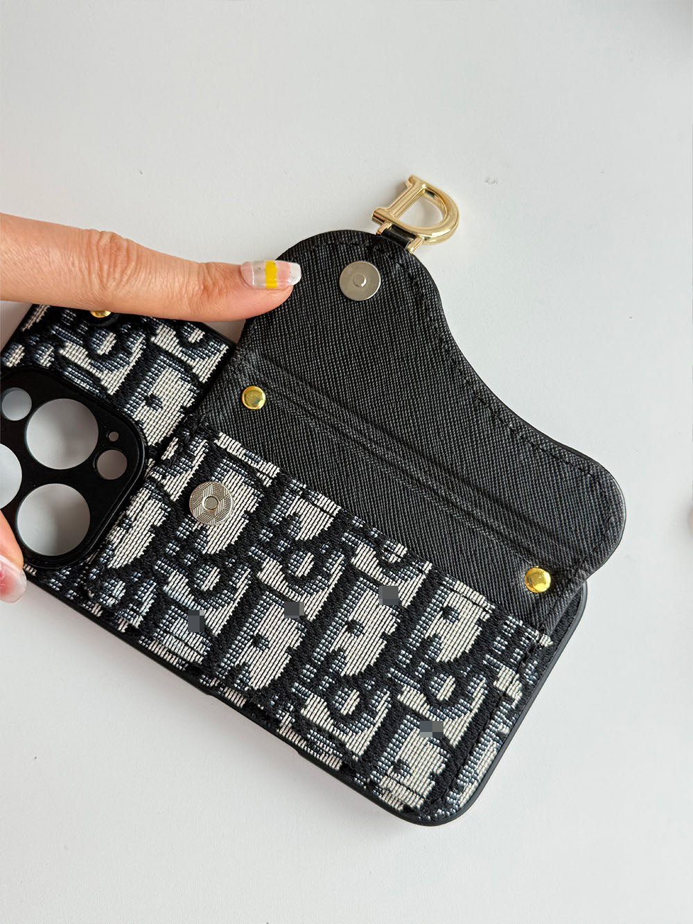 Black and cream geometric phone case with card-holder flap and gold-tone clip
