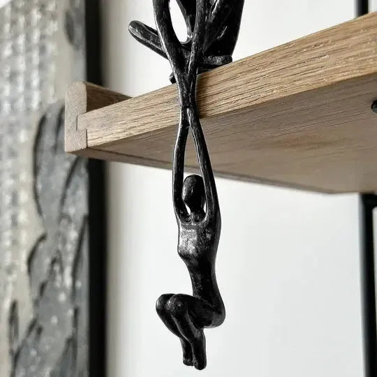 Black polystone figurine of two intertwined abstract human figures