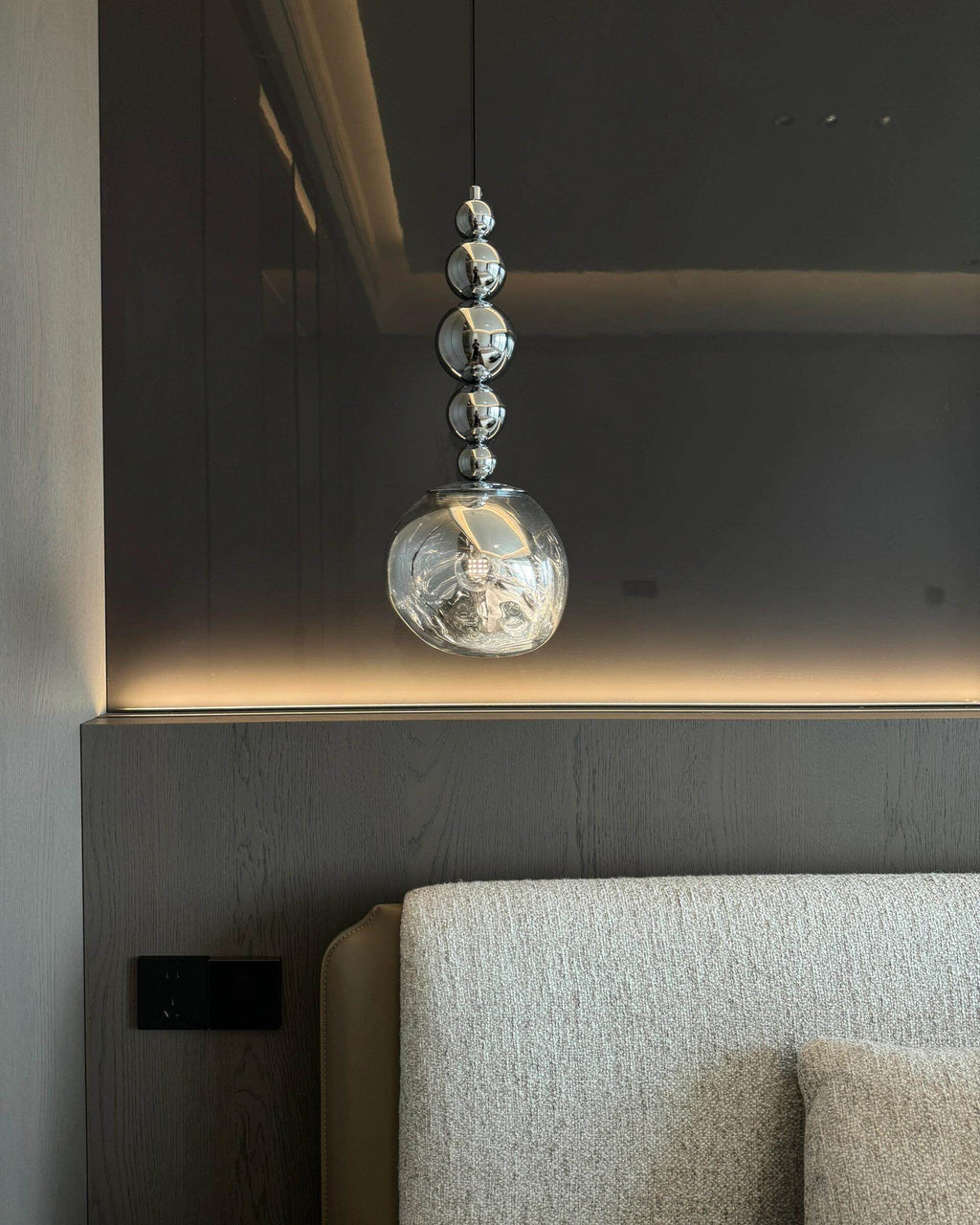Hanging pendant light with smoked glass shade and silver spherical detailing