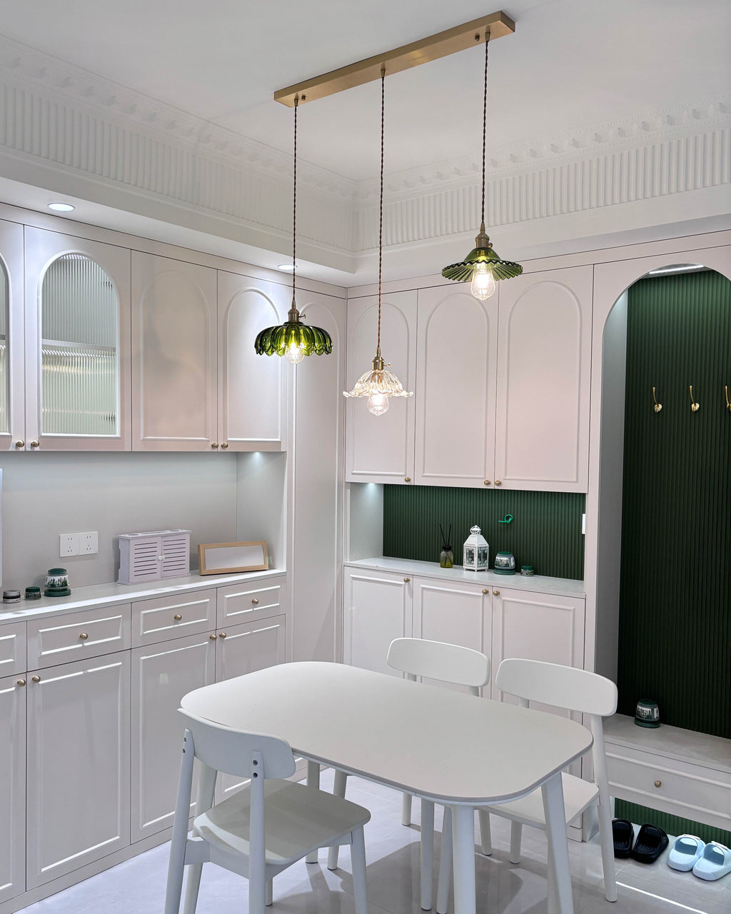 Three-shade pendant light with scalloped glass shades and brass-tone ceiling bar