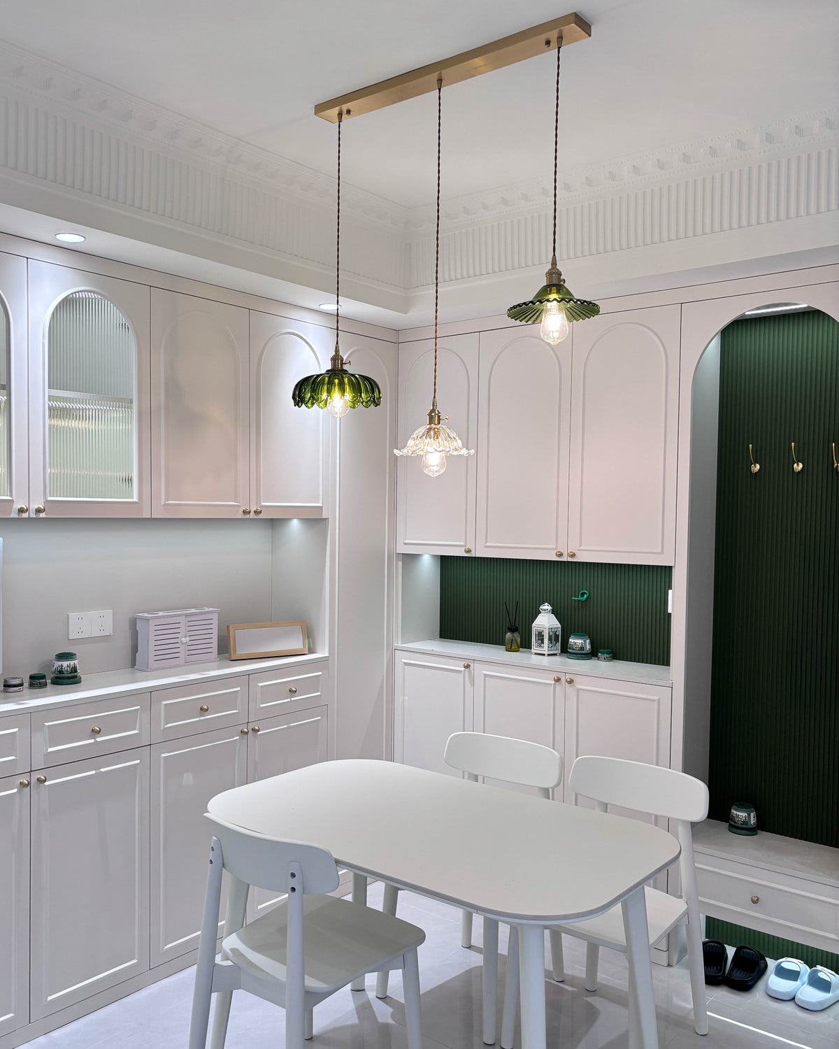 Three-shade pendant light with scalloped glass shades and brass-tone ceiling bar