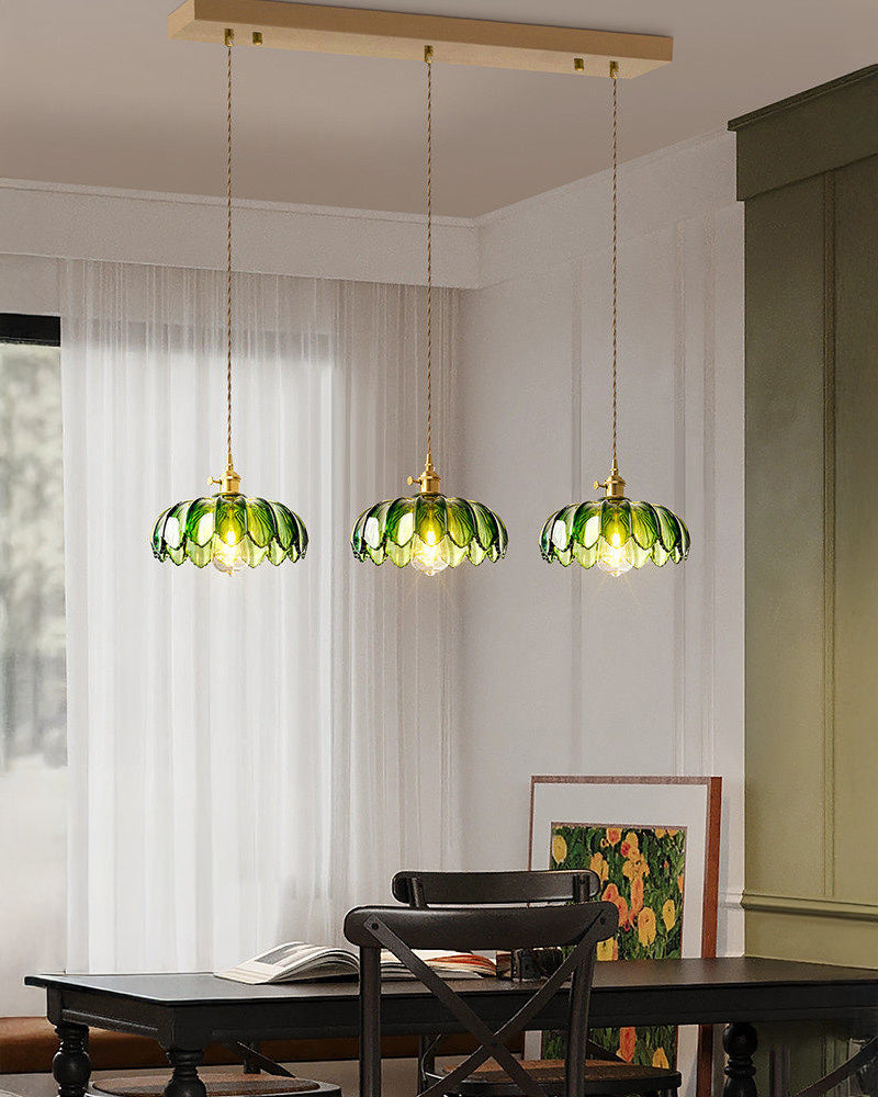 Three-shade pendant light with scalloped glass shades and brass-tone ceiling bar