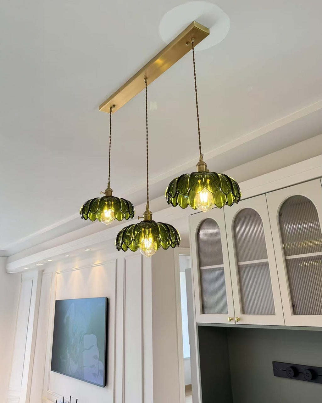 Three-shade pendant light with scalloped glass shades and brass-tone ceiling bar