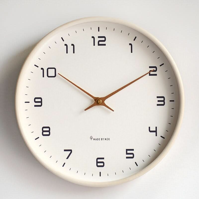 Round minimalist wall clock with large dark numerals and slim hands