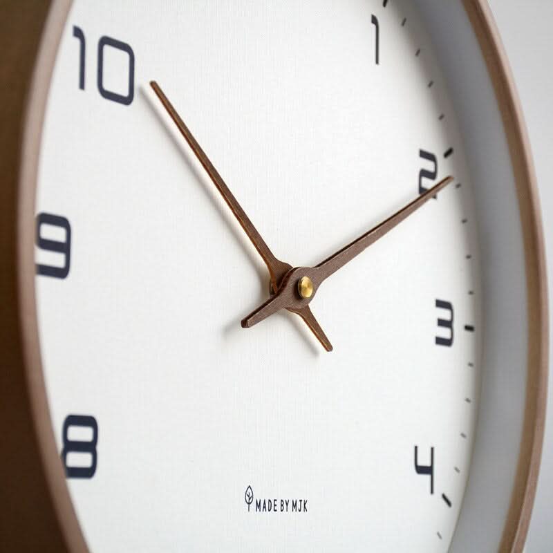 Round minimalist wall clock with large dark numerals and slim hands
