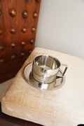 Silver handled coffee mug with matching round saucer