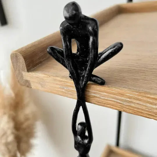 Black polystone figurine of two intertwined abstract human figures