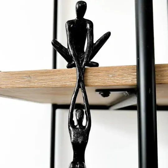 Black polystone figurine of two intertwined abstract human figures