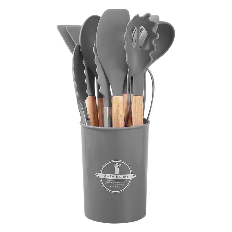 Silicone kitchen utensil set with wood-effect handles in a storage holder