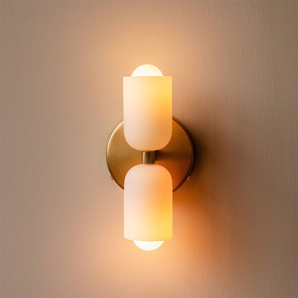 Double head wall sconce with two cylindrical shades and round wall plate