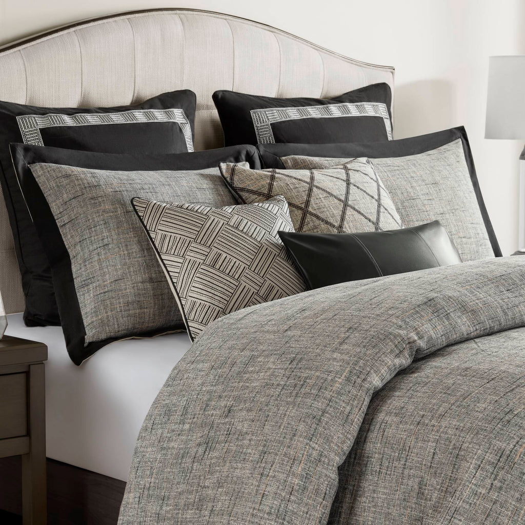 Grey textured jacquard comforter set arranged with geometric decorative pillows