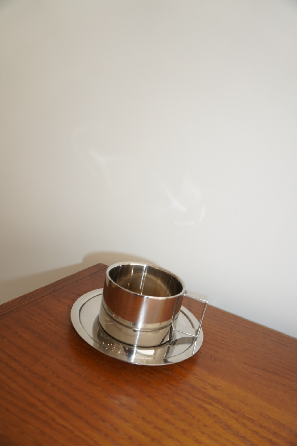 Silver handled coffee mug with matching round saucer