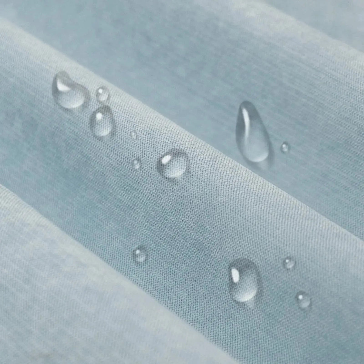 Solid light blue waterproof sofa cover draped over a sofa