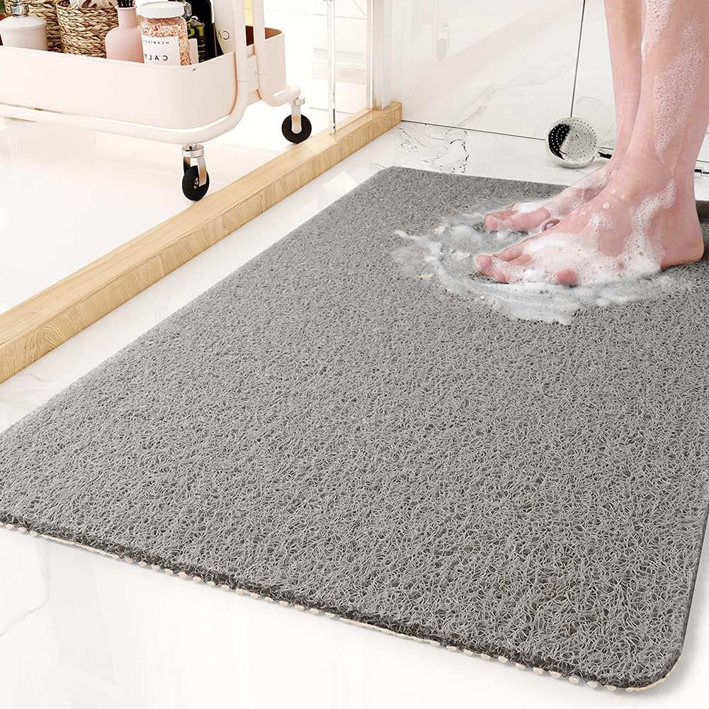 Textured rectangular non-slip shower mat beside a bathtub