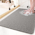 Textured rectangular non-slip shower mat beside a bathtub