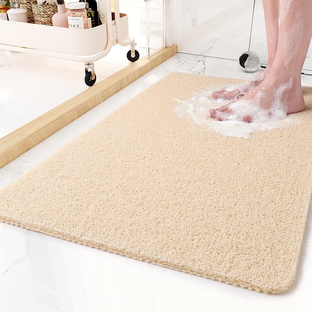 Textured rectangular non-slip shower mat beside a bathtub