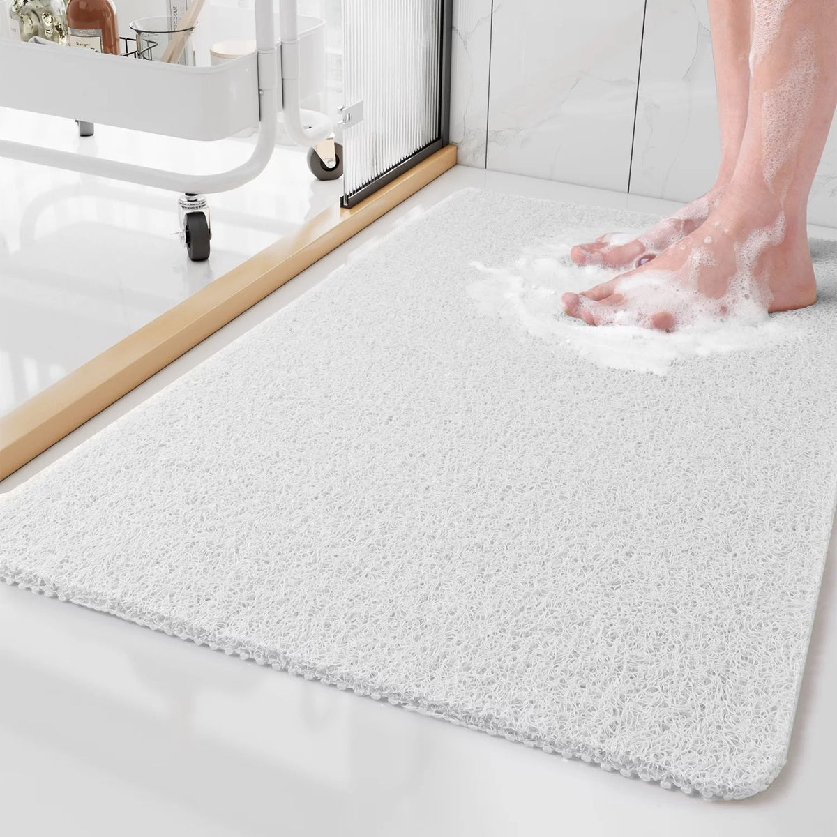Textured rectangular non-slip shower mat beside a bathtub