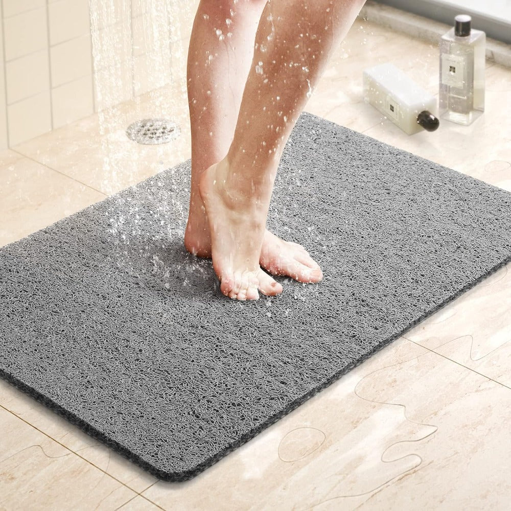 Textured rectangular non-slip shower mat beside a bathtub