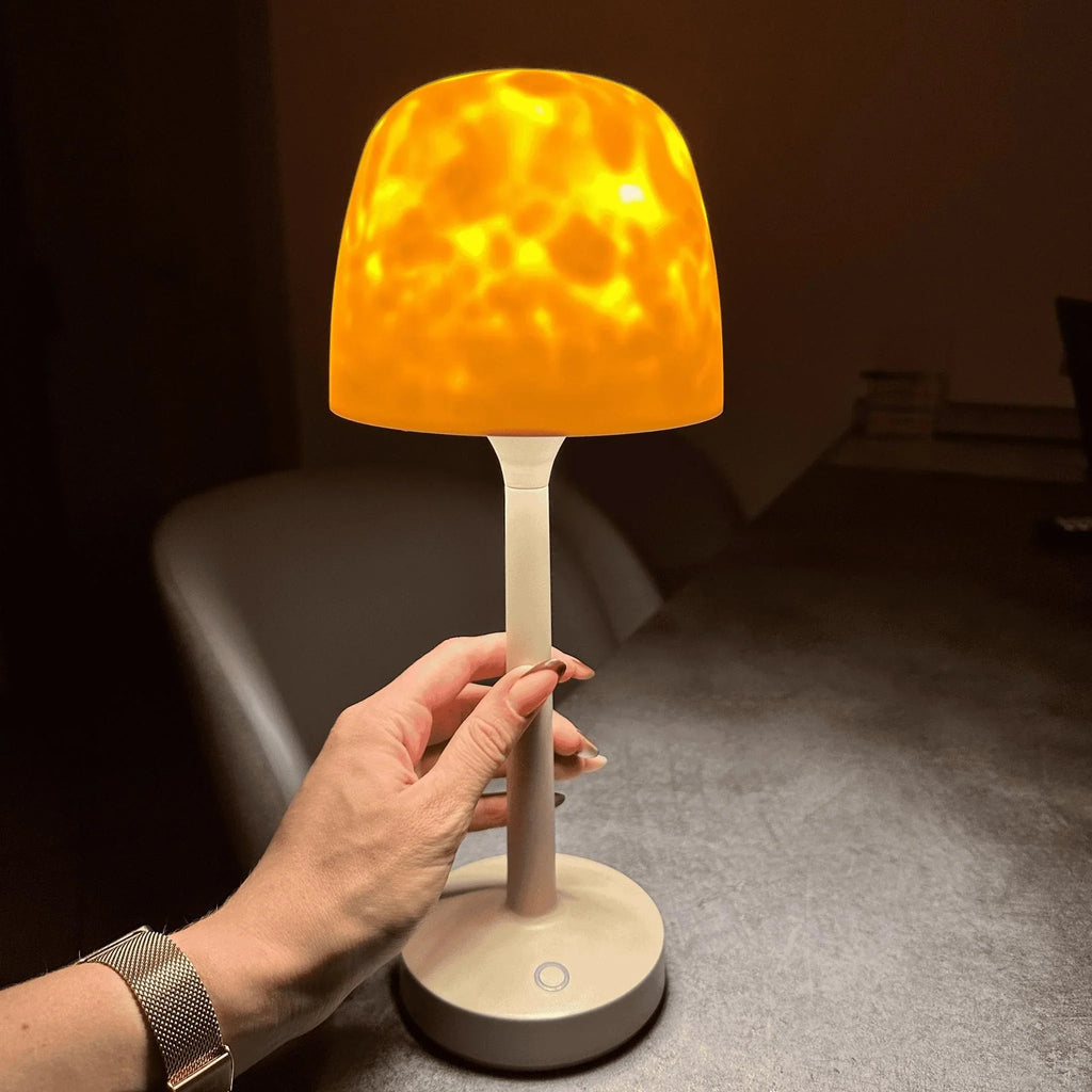 Cream wireless table lamp casting warm aurora-style light patterns