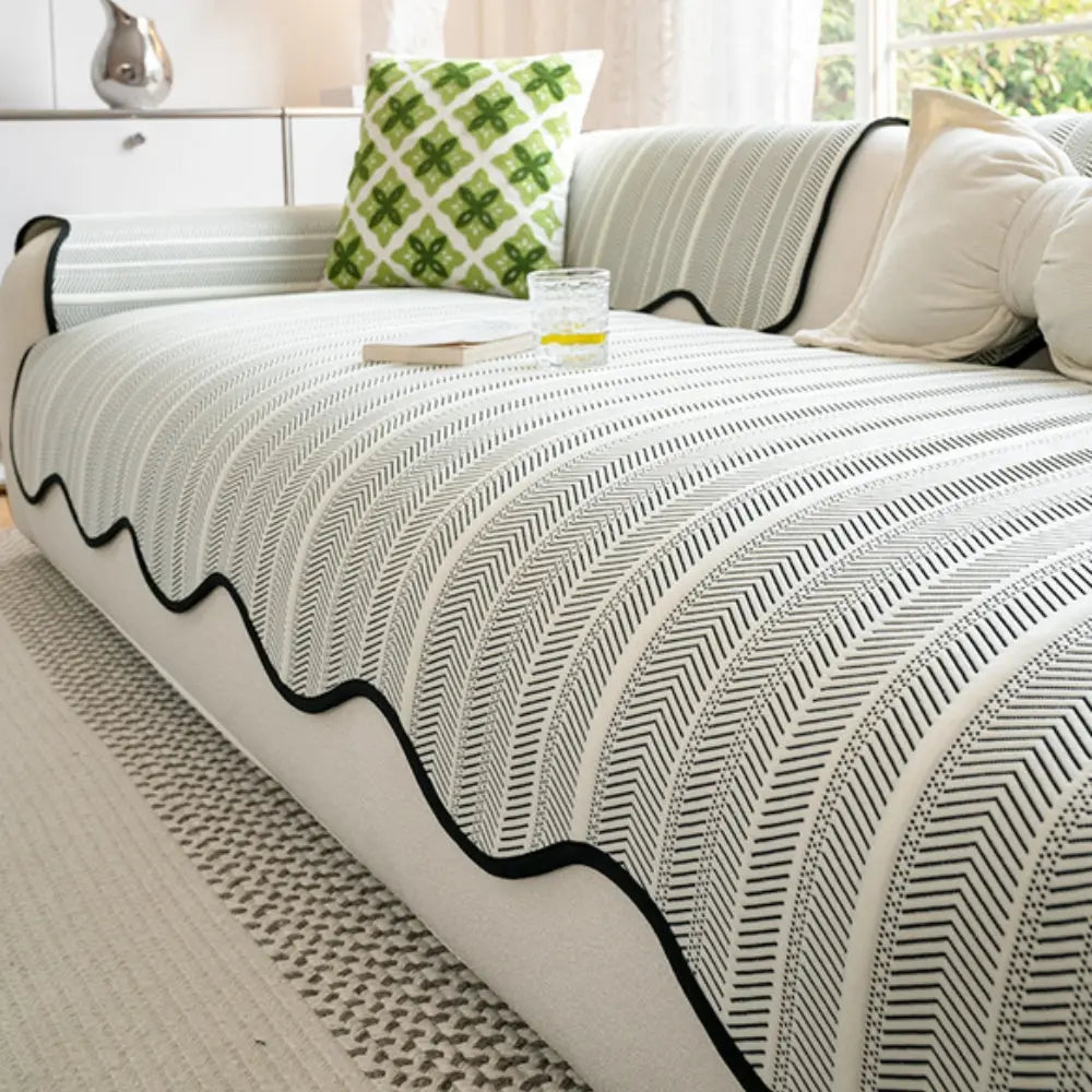 Textured herringbone sofa cover with decorative trim on a sofa