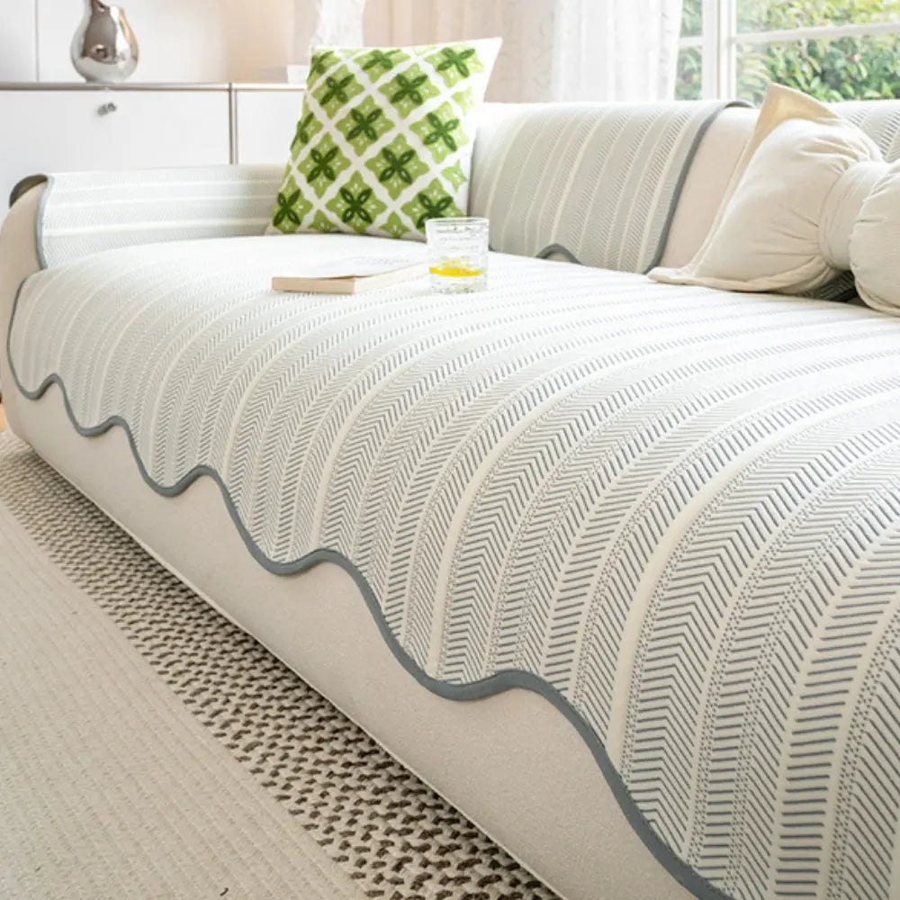 Textured herringbone sofa cover with decorative trim on a sofa