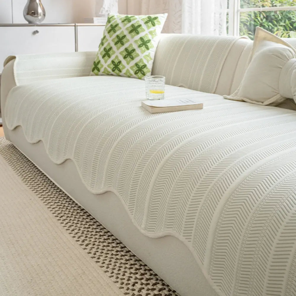 Textured herringbone sofa cover with decorative trim on a sofa