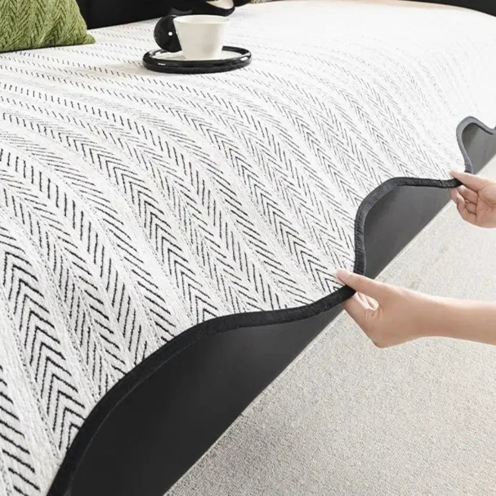 Textured herringbone sofa cover with decorative trim on a sofa