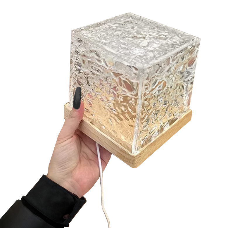 Textured clear cube table lamp glowing with colourful aurora effect light