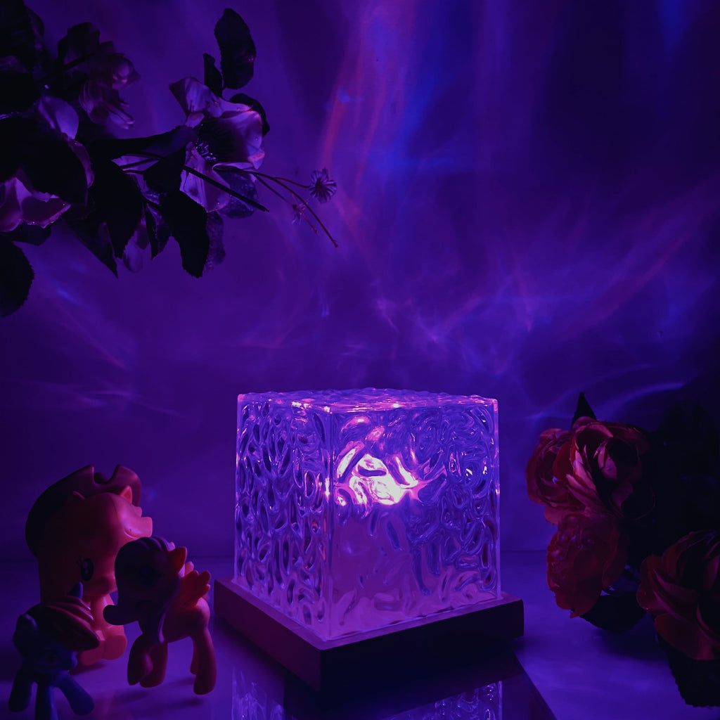 Textured clear cube table lamp glowing with colourful aurora effect light