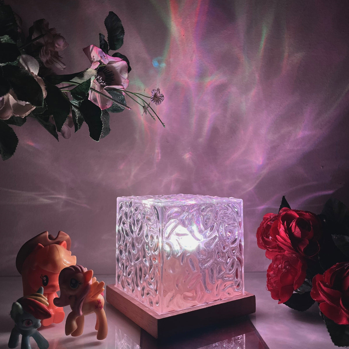 Textured clear cube table lamp glowing with colourful aurora effect light