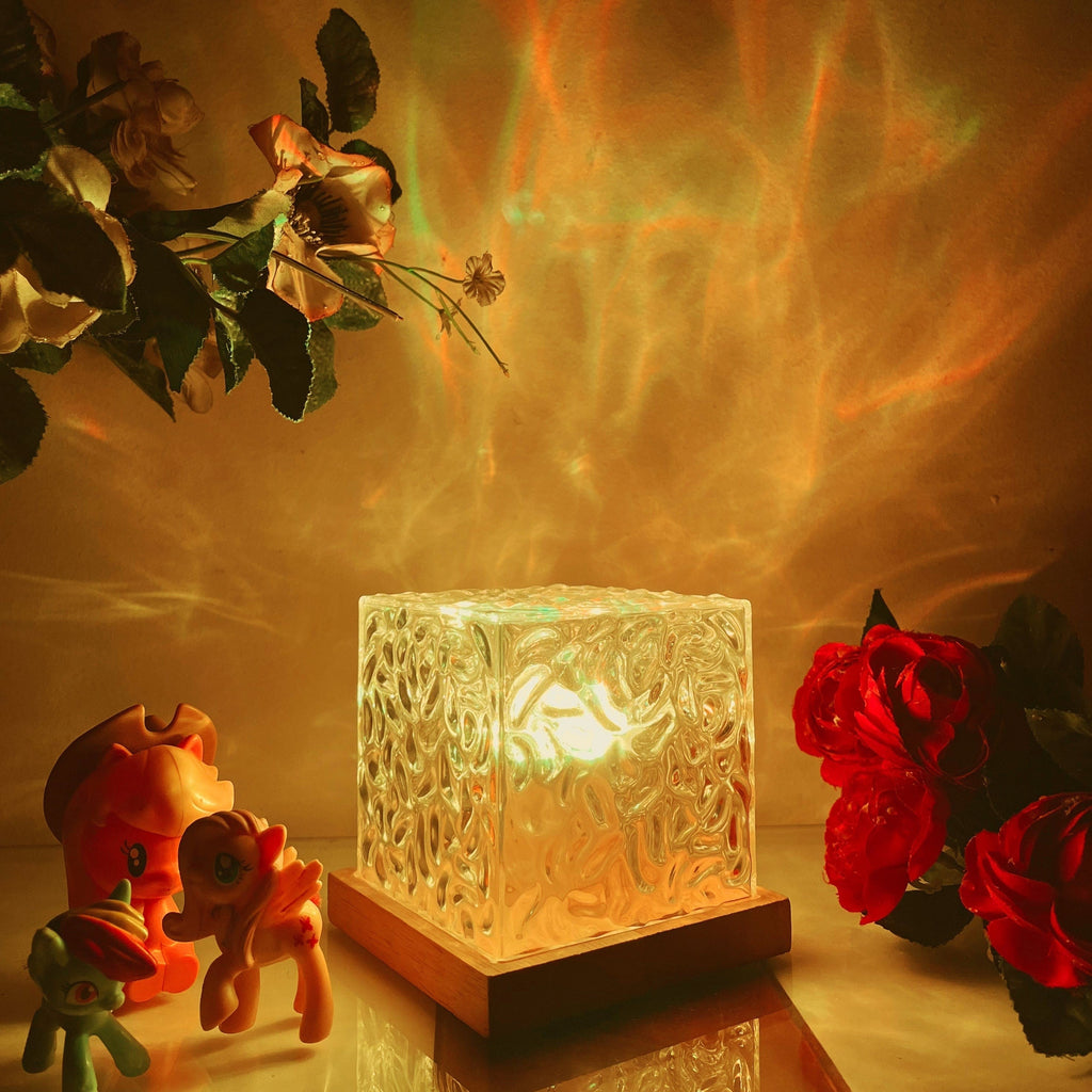 Textured clear cube table lamp glowing with colourful aurora effect light