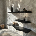 Black live edge floating wall shelves with sculptural contours and warm underside lighting