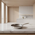 Silver titanium non-stick frying pan with hammered interior and long handle