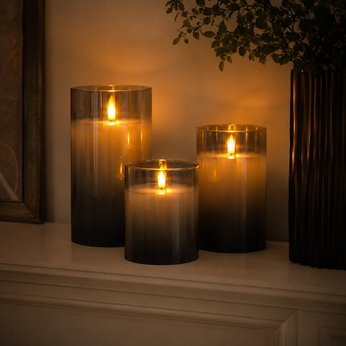 Three flameless cylindrical candle lights with flame-effect glow