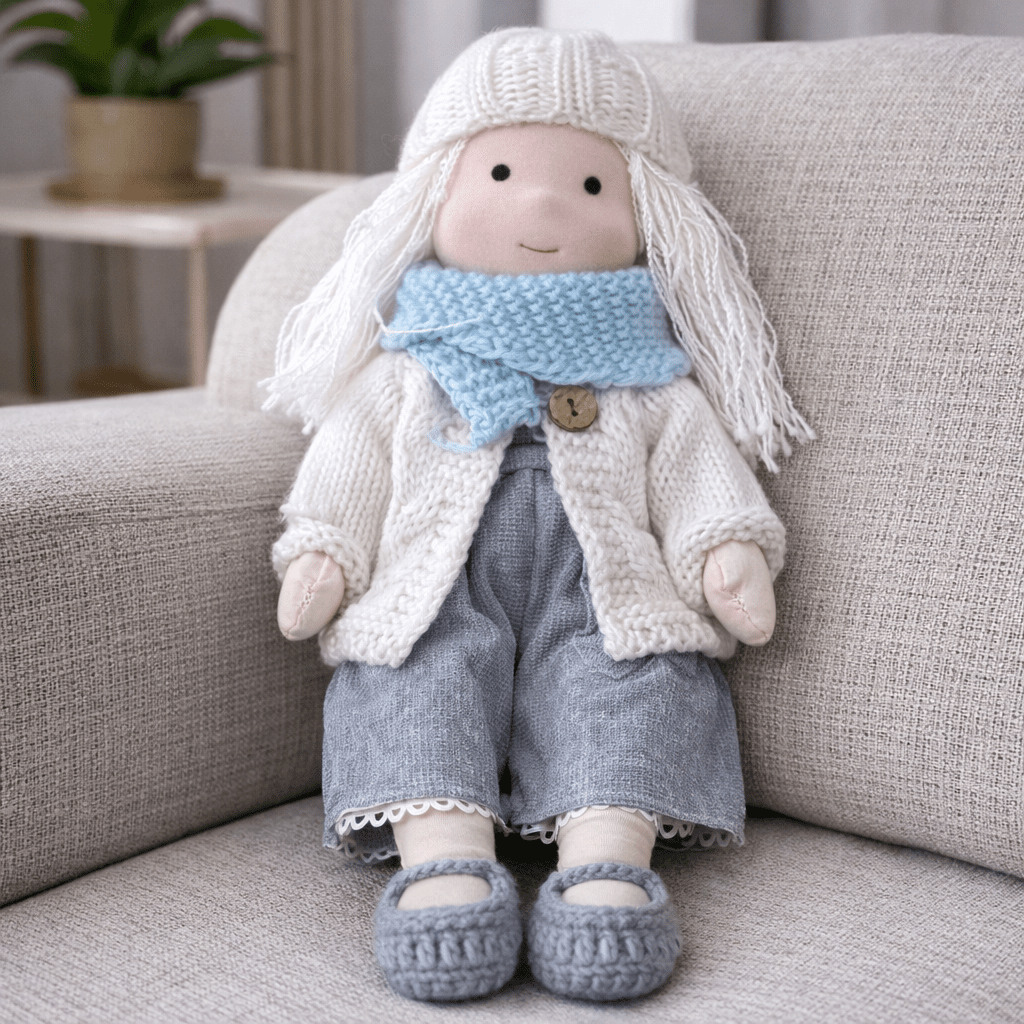Handmade Waldorf doll wearing knitted clothing and a patterned dress