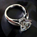 Silver-tone crystal engagement ring with a large clear centre stone and smaller side stones