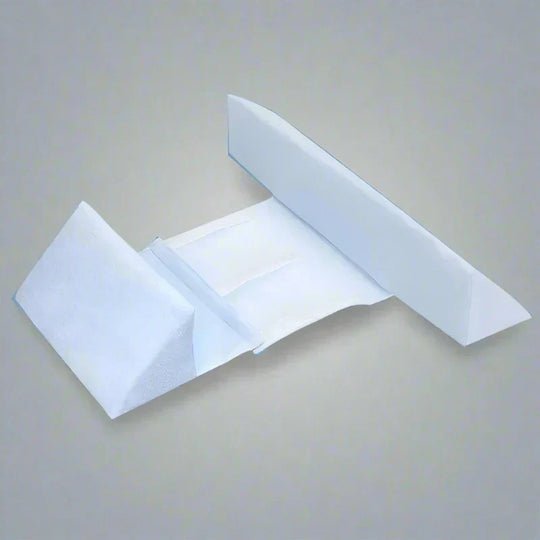 Baby positioning pillow with raised side supports in a cot