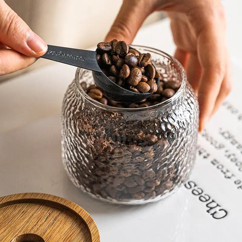 Clear hammered glass storage jar with dark timber lid