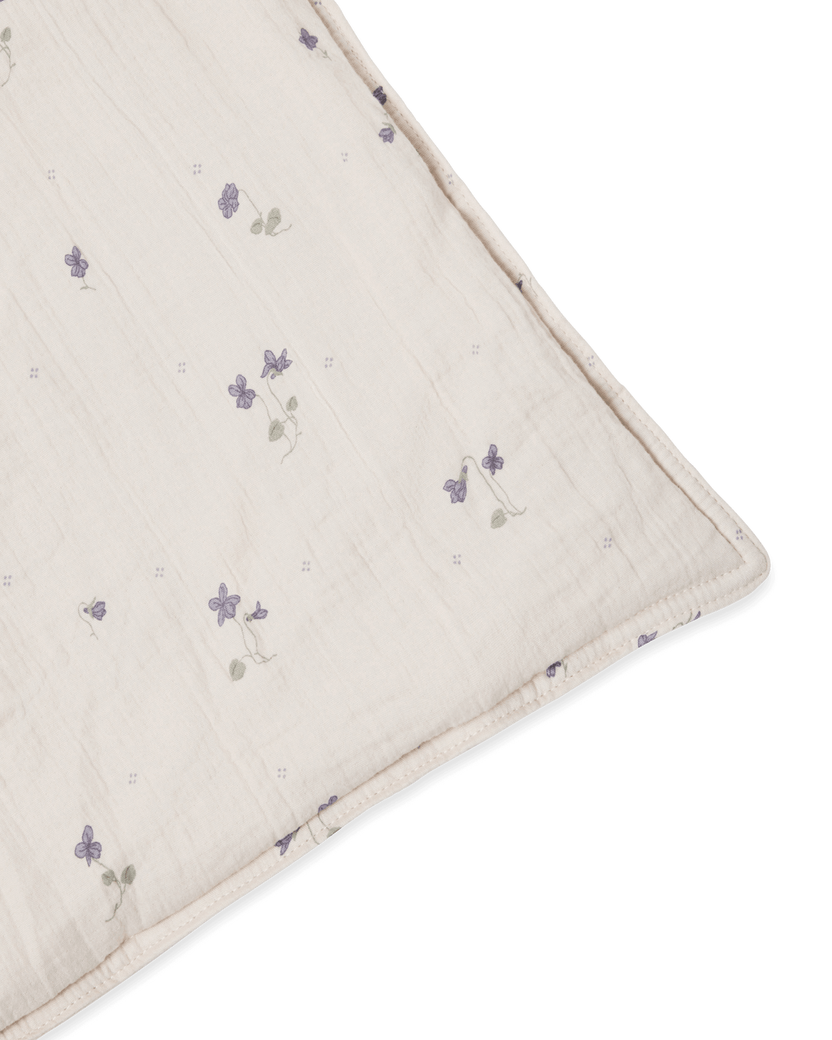 Beige muslin pillowcase with small purple floral pattern and gathered texture