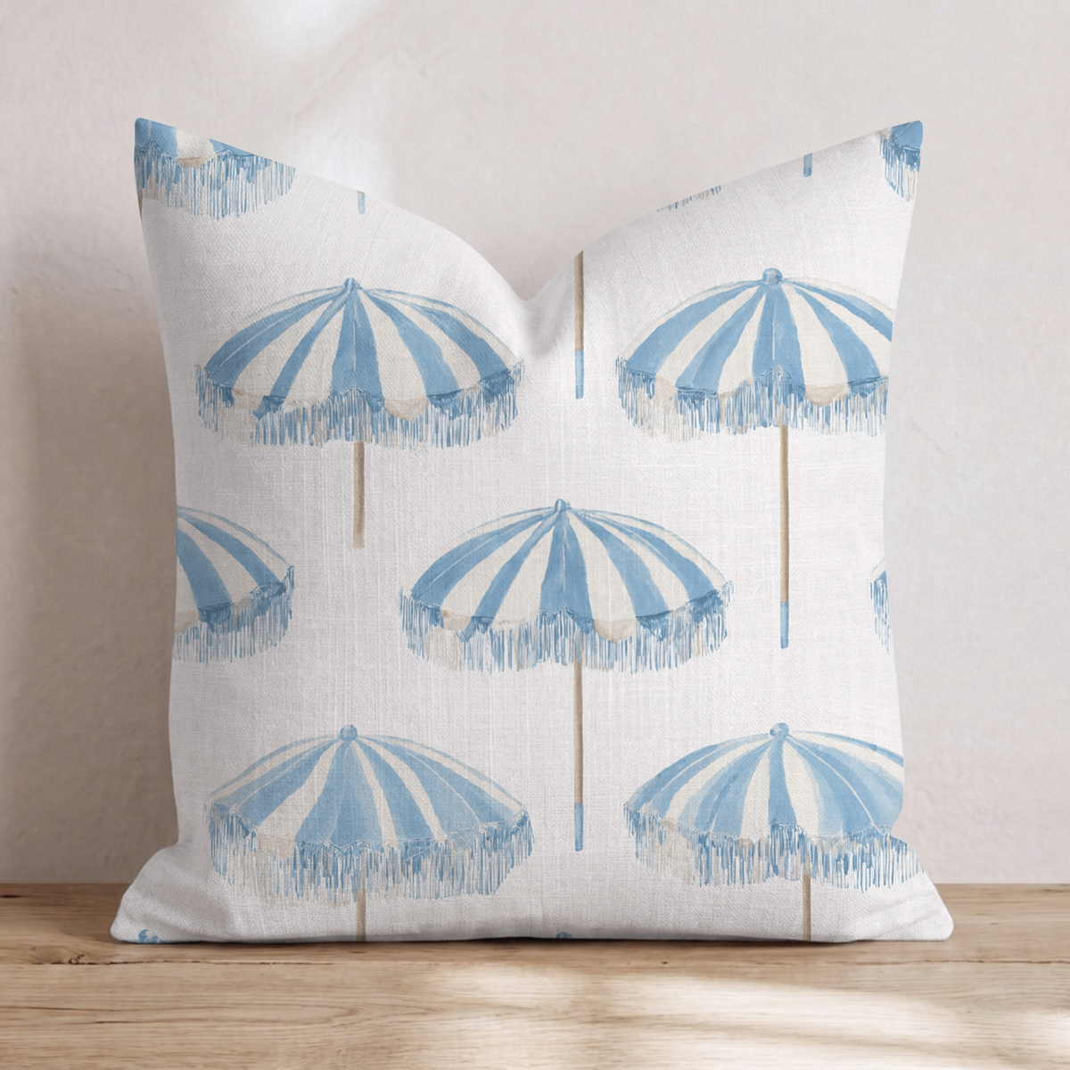 White square throw pillow with a blue umbrella pattern
