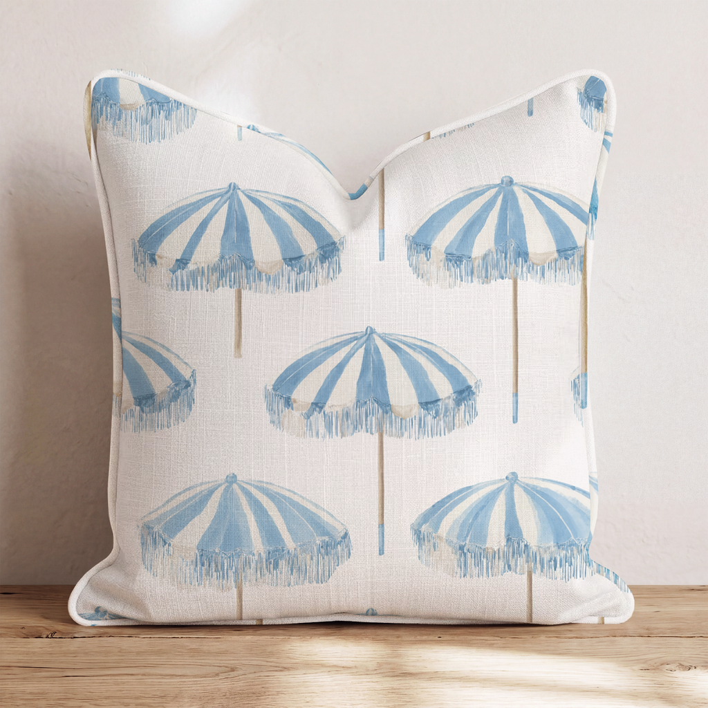 White square throw pillow with a blue umbrella pattern