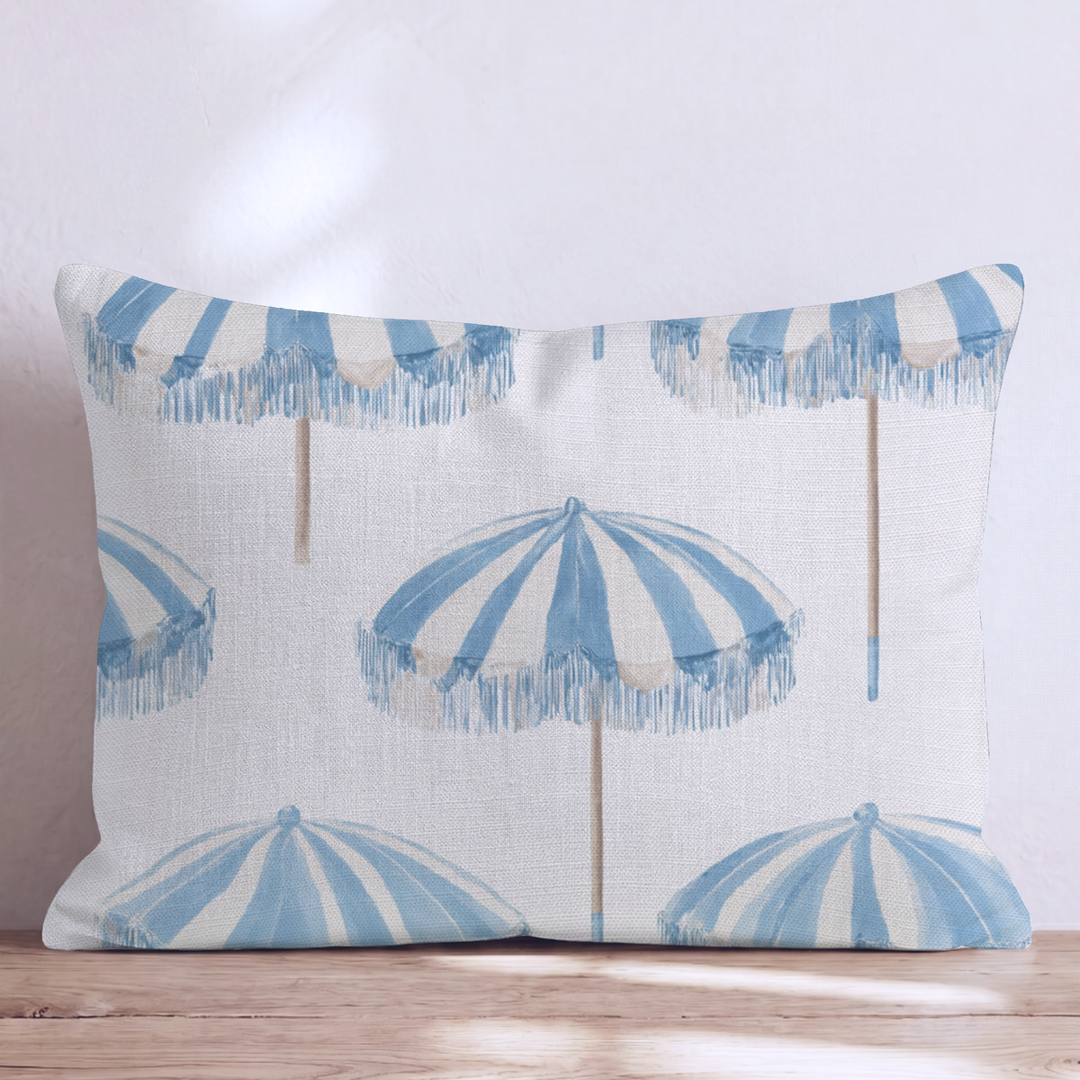 White square throw pillow with a blue umbrella pattern